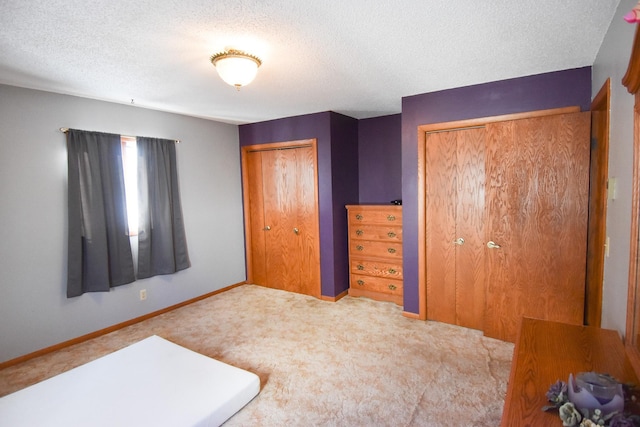 102 6th St SW, Red Lake Falls, MN 56750 - unfurnished bedroom featuring carpet floors, a textured ceiling, and two closets
