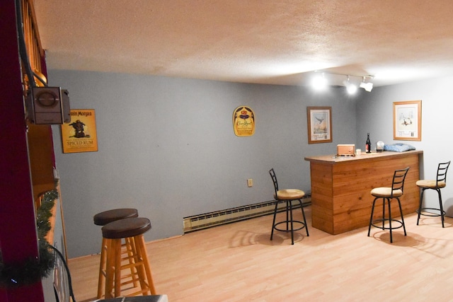 102 6th St SW, Red Lake Falls, MN 56750 - bar area with a baseboard heating unit, wood finished floors, a textured ceiling, and rail lighting
