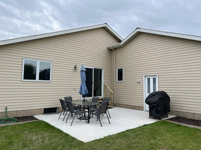 rear view of house featuring a patio area and a lawn