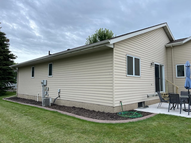 rear view of house with central air condition unit, a patio, and a lawn