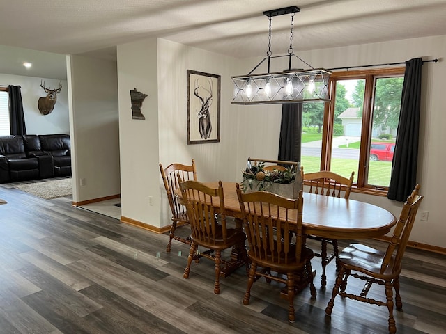 dining space with baseboards and wood finished floors