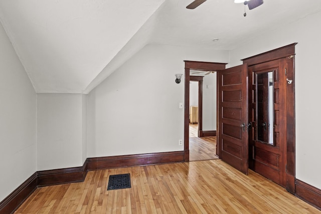 additional living space with ceiling fan, lofted ceiling, radiator, and light hardwood / wood-style flooring