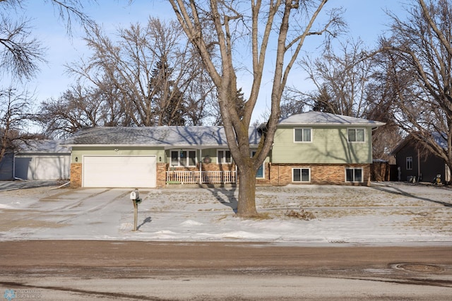 tri-level home with covered porch and a garage