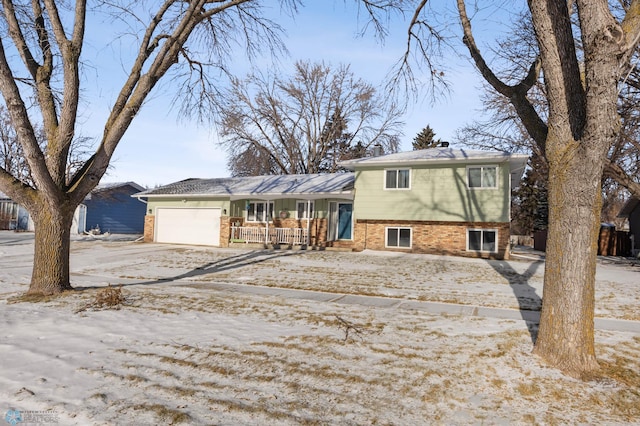 split level home with covered porch and a garage