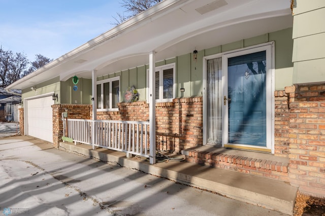 doorway to property with a porch and a garage