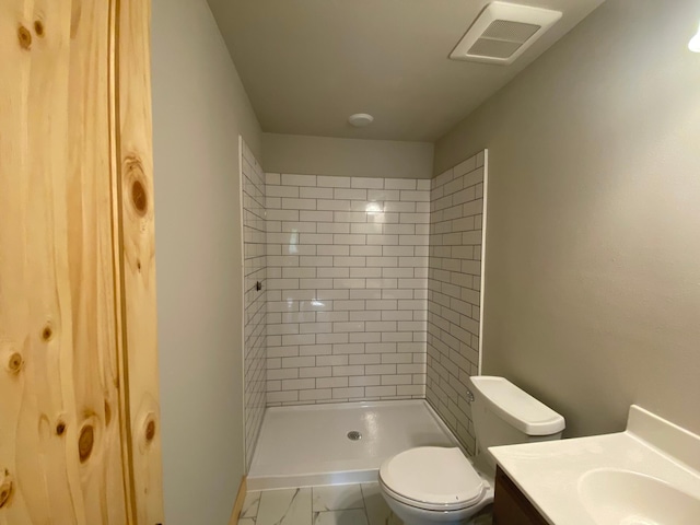 3450 23rd Ave NW, Hackensack, MN 56452 - bathroom featuring toilet, a tile shower, vanity, and marble look tile flooring