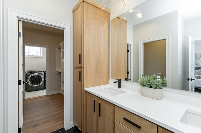2665 Timber Oaks Rd SW, Rochester, MN 55902 - ensuite bathroom featuring washer / dryer, double vanity, and wood finished floors