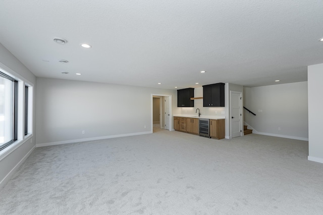 2665 Timber Oaks Rd SW, Rochester, MN 55902 - unfurnished living room with wet bar, wine cooler, light carpet, recessed lighting, and stairs