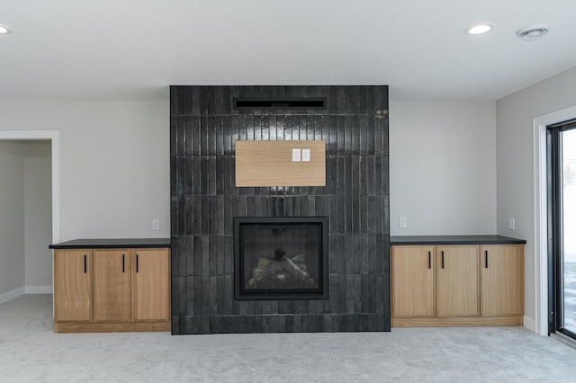 2665 Timber Oaks Rd SW, Rochester, MN 55902 - unfurnished living room with carpet floors, a tiled fireplace, and recessed lighting