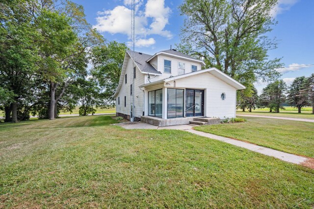 view of front facade with a sunroom and a front lawn