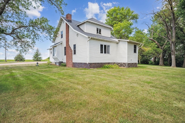 view of property exterior featuring a shingled roof, a yard, and a chimney