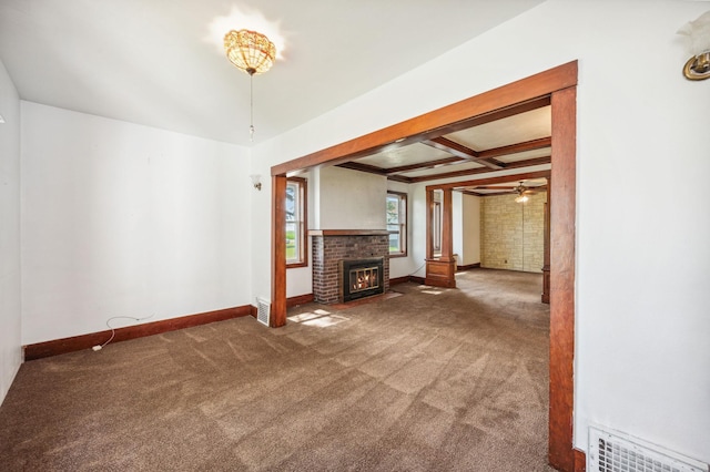 unfurnished living room with baseboards, visible vents, coffered ceiling, carpet flooring, and a brick fireplace