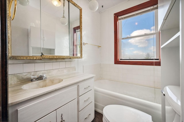 full bath featuring a bathtub, vanity, toilet, and tasteful backsplash