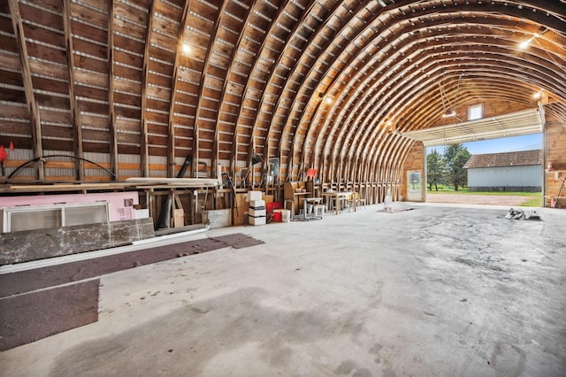 miscellaneous room with concrete flooring and vaulted ceiling