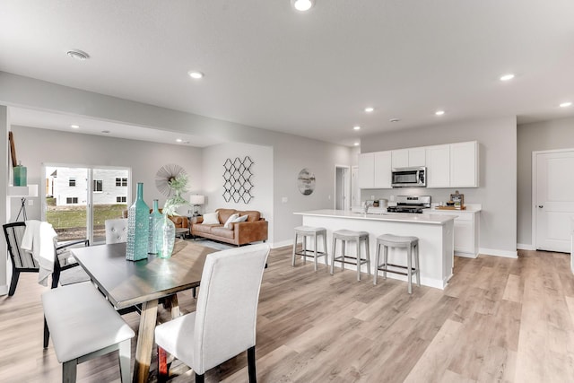 dining space featuring light wood-style floors, recessed lighting, and baseboards