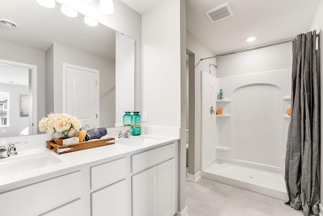 bathroom with visible vents, a sink, and a shower stall