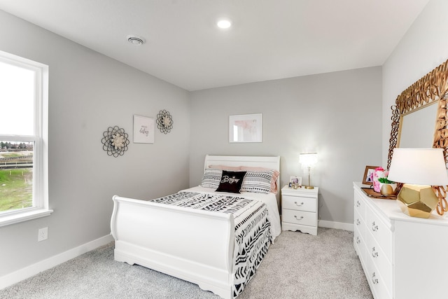 bedroom with light carpet and baseboards