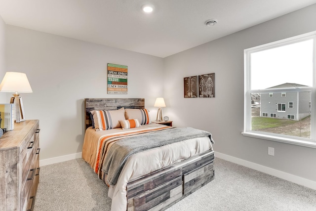 bedroom with baseboards and light colored carpet