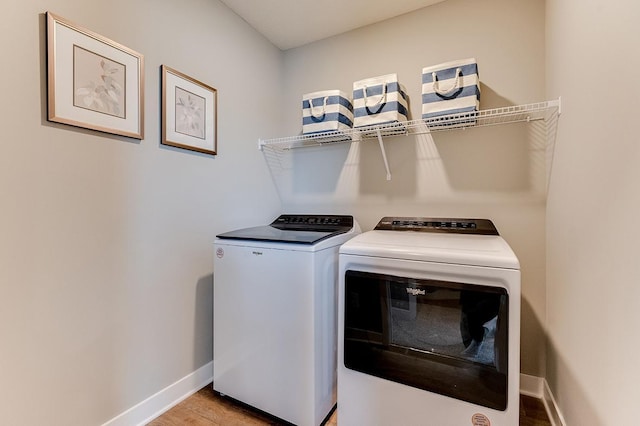 laundry room with light wood-style floors, laundry area, baseboards, and separate washer and dryer