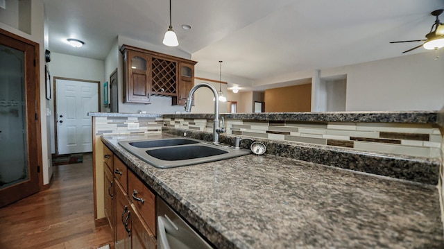 kitchen featuring pendant lighting, sink, ceiling fan, decorative backsplash, and dark wood-type flooring