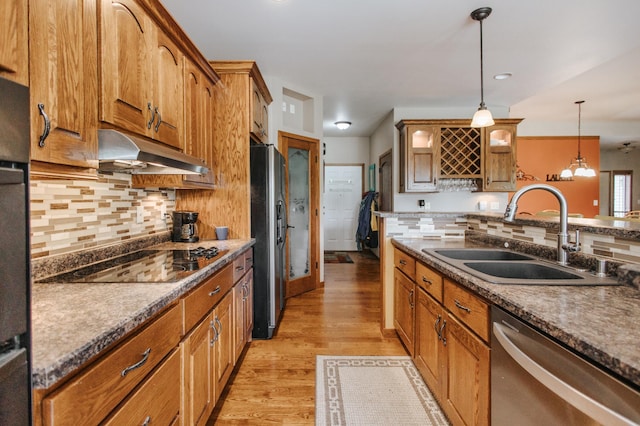 kitchen featuring backsplash, light hardwood / wood-style flooring, stainless steel appliances, sink, and pendant lighting