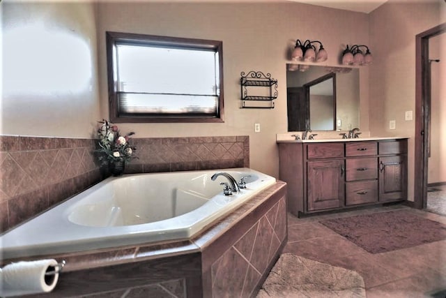 bathroom with tiled tub, vanity, and tile patterned flooring