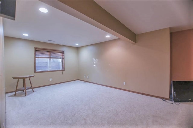 carpeted empty room with beam ceiling