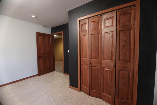 unfurnished bedroom featuring a closet and light carpet