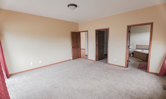 unfurnished bedroom with carpet flooring and ensuite bath