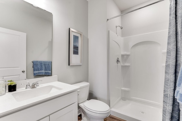 bathroom featuring wood-type flooring, vanity, toilet, and a shower with curtain