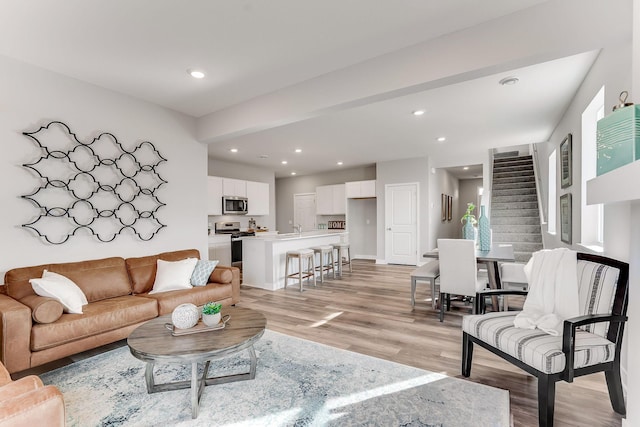 living room with sink and light hardwood / wood-style flooring