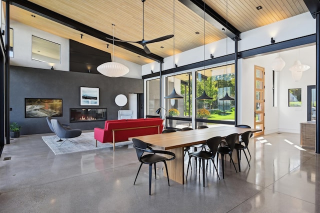 dining space with ceiling fan, beam ceiling, wood ceiling, concrete flooring, and high vaulted ceiling