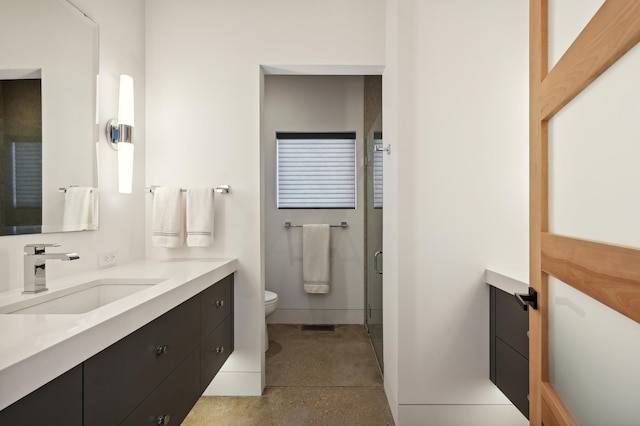 bathroom with vanity, a shower with shower door, and toilet