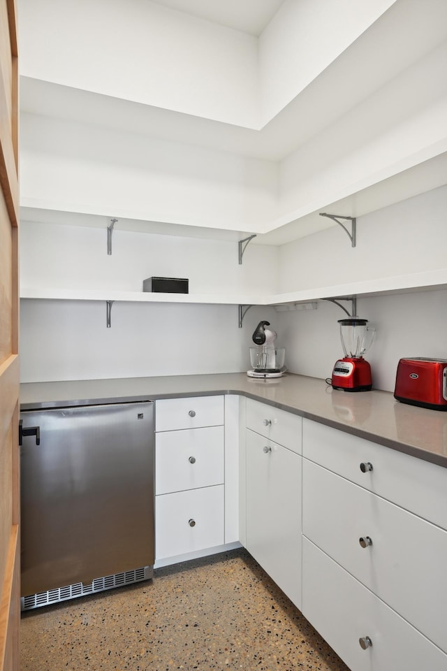 kitchen featuring stainless steel dishwasher and white cabinetry