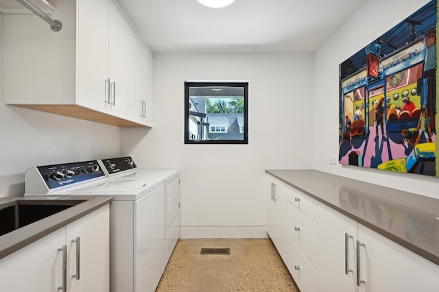 laundry area with washer and dryer and cabinets