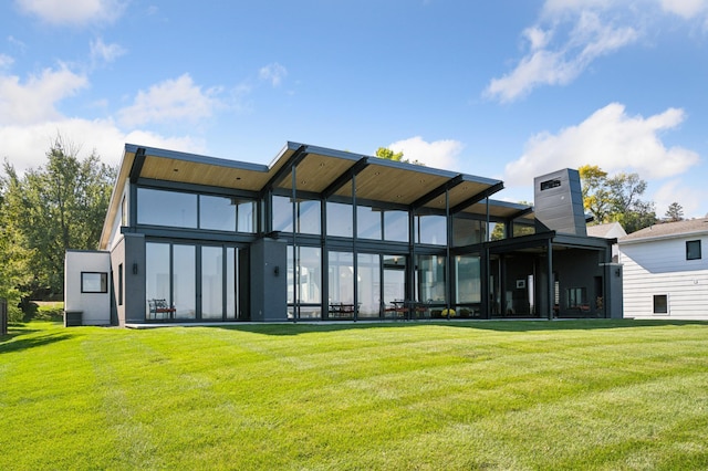 back of house with a sunroom and a lawn