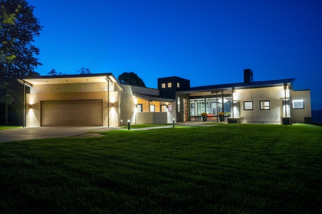 view of front of property with a garage and a lawn