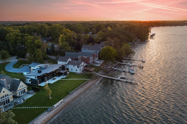 aerial view at dusk featuring a water view