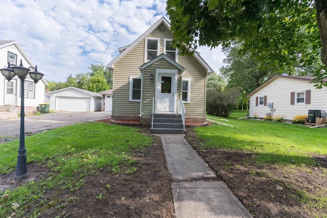 bungalow-style house featuring a front yard, a garage, and an outbuilding