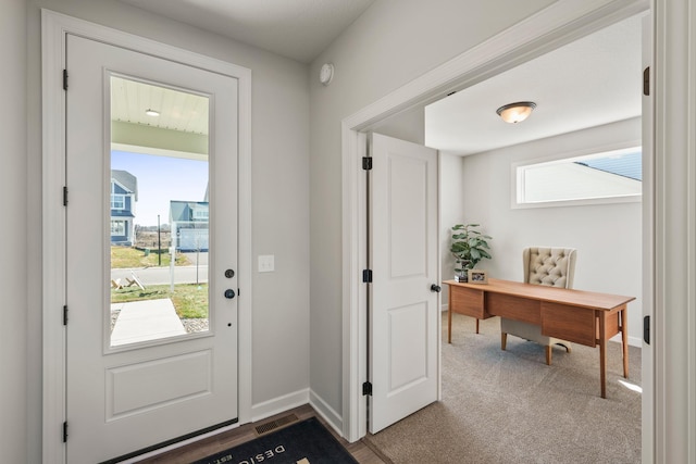 doorway to outside featuring a healthy amount of sunlight and carpet