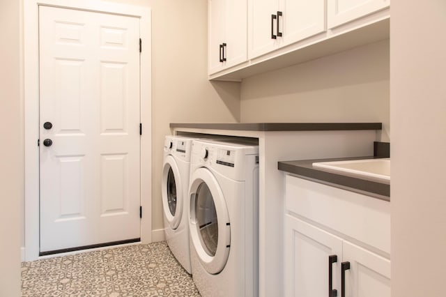 clothes washing area with tile patterned floors, cabinet space, and washing machine and clothes dryer