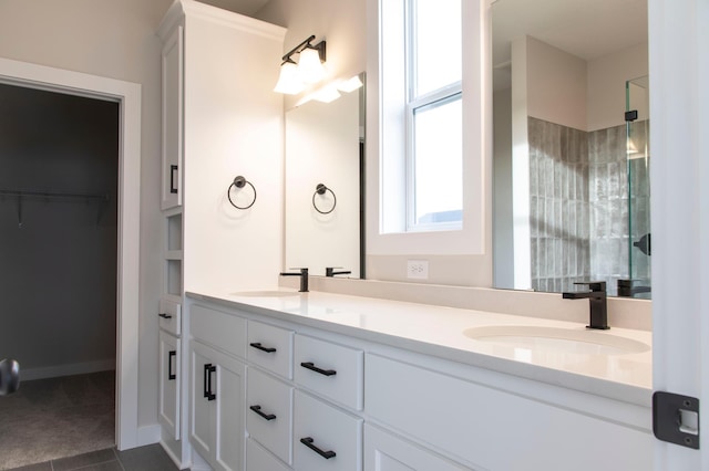 full bath featuring a shower stall, a spacious closet, double vanity, and a sink