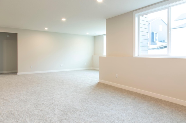 unfurnished room featuring light carpet, recessed lighting, a healthy amount of sunlight, and baseboards