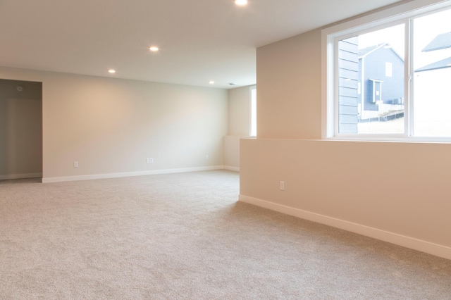 spare room with recessed lighting, light colored carpet, and baseboards