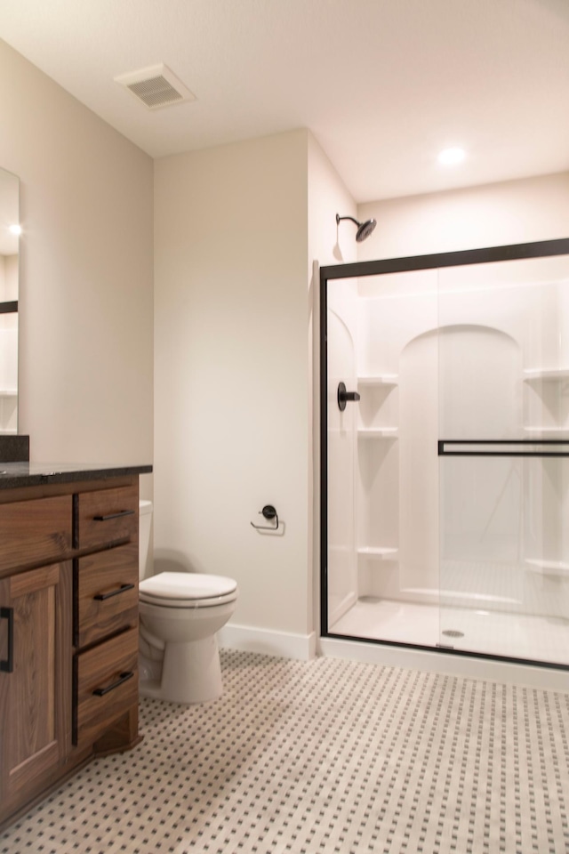 bathroom featuring vanity, baseboards, visible vents, a shower stall, and toilet