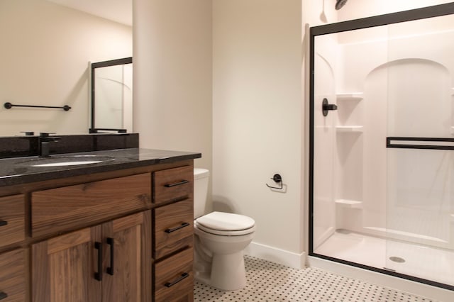 full bath featuring a stall shower, toilet, vanity, and baseboards