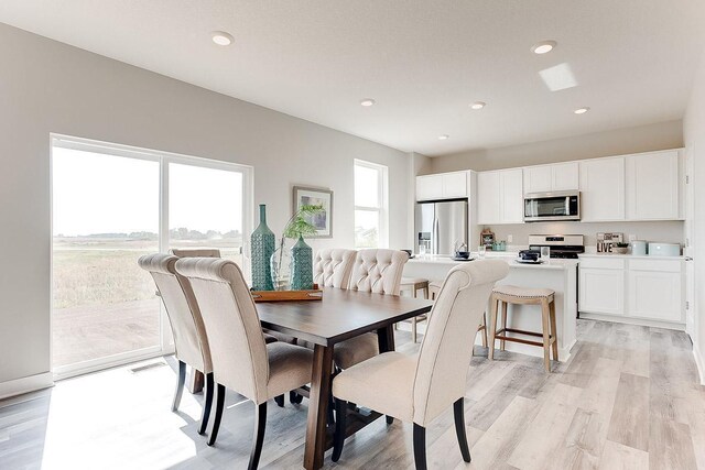 dining room with light wood finished floors and recessed lighting