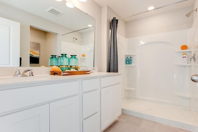 full bath with double vanity, a shower with shower curtain, a sink, and visible vents