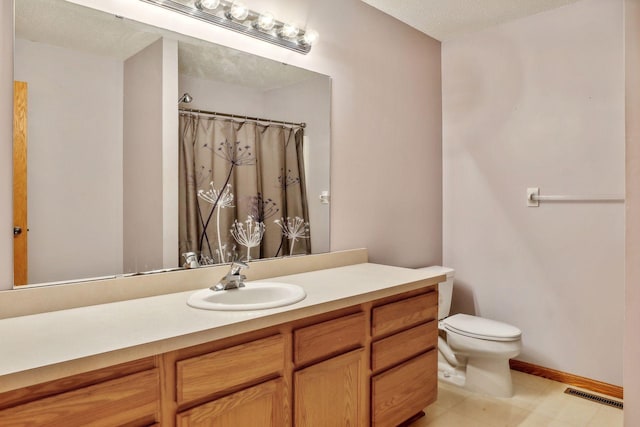 bathroom featuring vanity, toilet, curtained shower, and a textured ceiling