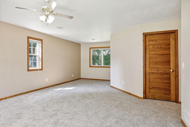 spare room featuring ceiling fan and light carpet